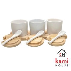 three cups and two spoons sitting on a wooden tray with the name kami house