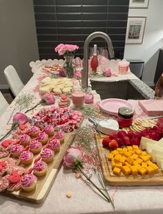 a table topped with lots of different types of desserts and pastries on top of wooden cutting boards