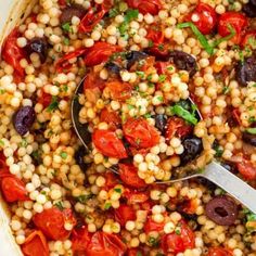 a pot filled with corn, tomatoes and olives