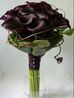 a bouquet of purple flowers in a clear vase