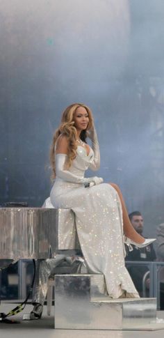 a woman sitting on top of a silver piano