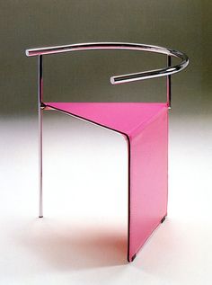 a pink chair sitting on top of a white table next to a metal rack with a handle