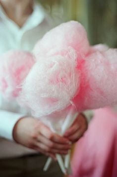 pink cotton candy lollipops being held by two women