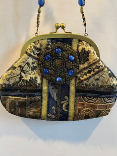 "Step into elegance with our Vintage Blue and Gold Beaded Woman's Purse. This exquisite antique handbag features a captivating blend of colors and intricate beadwork, a true testament to timeless craftsmanship. Elevate your ensemble and make a statement of sophistication with this stunning accessory - a fusion of history and style. This purse is in Vintage Excellent Measurement's : 9.5\" Long 7\" High 13\" High to Handle Review all pictures closely. Most of my items are vintage and used, they will all show some signs of light wear or use. Major flaws will be noted in the description. Items are sold \"as is\" so please make sure you look at all pictures carefully. I have done my best to capture color and size. I am not an expert on vintage items but I do my best to describe items I have lis Bohemian Rectangular Shoulder Bag For Formal Occasions, Formal Bohemian Rectangular Shoulder Bag, Formal Blue Embellished Bags, Blue Beaded Evening Bag For Formal Occasions, Bohemian Embellished Bags For Formal Occasions, Bohemian Embellished Formal Bags, Bohemian Blue Bags As Fashion Accessory, Blue Traditional Formal Bag, Traditional Blue Formal Bags