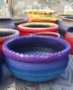 many different colored vases sitting on top of a wooden table next to each other