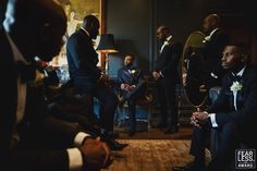 a group of men in tuxedos are sitting down and talking to each other