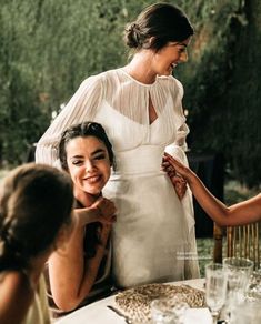 two women sitting at a table with plates and wine glasses