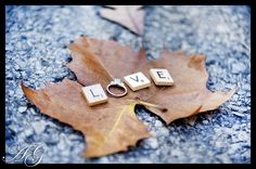 the word love spelled with cubes on top of a maple leaf and ring resting on it