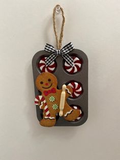 an ornament shaped like a muffin pan with gingerbreads on it