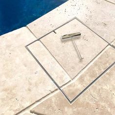 a pool with a tile floor next to it and a metal object in the middle