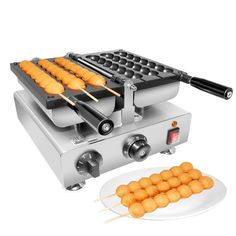 an electric griddle grill with food on it and two skewers next to it