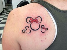 the back of a woman's shoulder with a minnie mouse tattoo on it