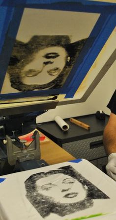 a man in black shirt and white gloves working on a photo