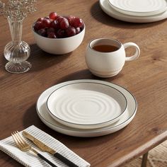 the table is set with white dishes and silverware