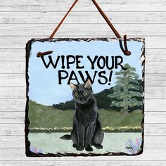 a sign with a black cat saying wipe your paws