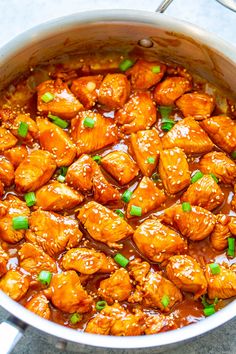 a pot filled with chicken and sauce on top of a table