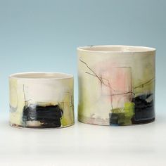 two ceramic cups sitting next to each other on a table