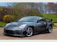 a black sports car parked in front of some bushes