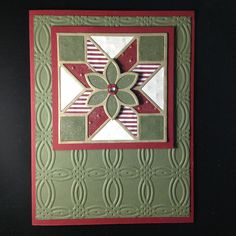 a close up of a card with a flower on the front and an embellishment in the middle