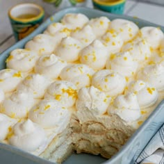 a blue dish filled with lemon meringue and white frosted desserts on top of a table