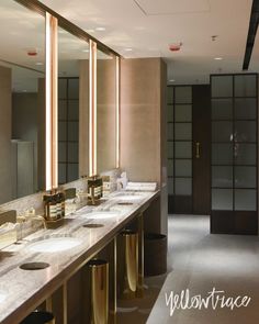 a bathroom with two sinks, mirrors and lights on the wall next to each other