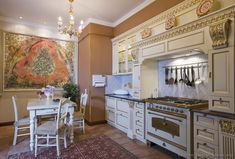 a kitchen with an oven, stove and dining room table in the background is a tapestry hanging on the wall