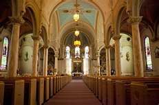 the inside of a church with pews and stained glass windows