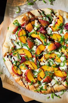 a pizza sitting on top of a cutting board covered in cheese and fruit toppings