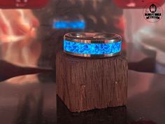 a ring that is sitting on top of a piece of wood with blue lights in the background