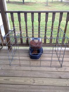 the bird feeder on the deck is full of birdseed and other things to eat