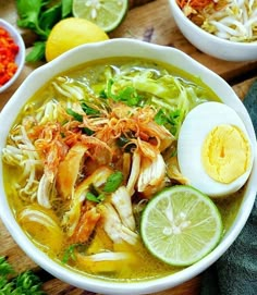 two bowls filled with soup and garnished with limes