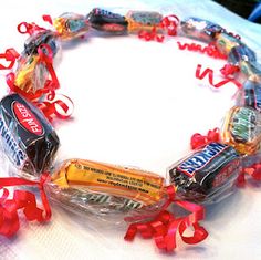 an assortment of candy wrapped in plastic on top of a white cloth covered tablecloth