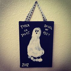 a sign hanging on the wall with a ghost drawn on it that says trick or treat 2012