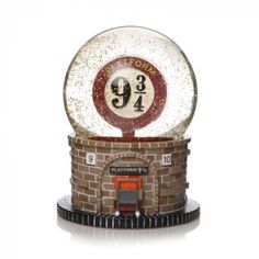 a snow globe sitting on top of a brick building with a red and white clock