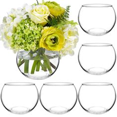 a vase filled with yellow and white flowers next to four empty glasses on a white background