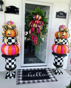 two decorated pumpkins sitting on top of each other in front of a door way