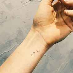 a person's arm with a small tattoo on the left side of their wrist