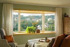 a bedroom with a bed, chair and window in front of the windowsills