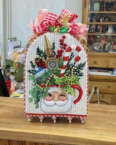 a christmas card holder with a santa clause and candy canes on it's head