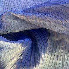 an image of blue fabric that looks like it has been folded in the wind and is very soft