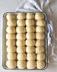 a pan filled with uncooked dough on top of a white countertop next to a blue towel