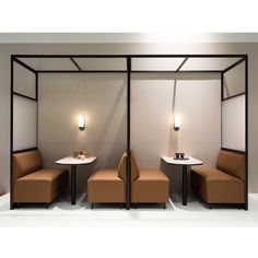 two chairs and a table in a room with lights on the wall behind them,