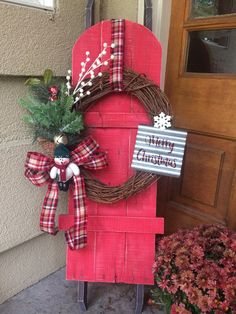 a red wooden sled with a wreath on it