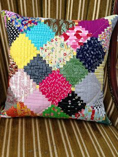 a colorful pillow sitting on top of a chair