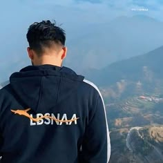 a man standing on top of a mountain looking at the mountains