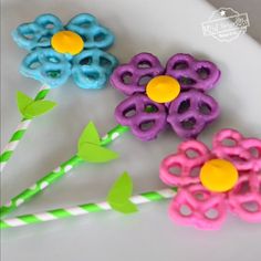 three flower shaped straws sitting on top of a white plate