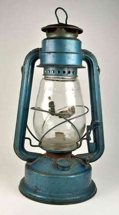 an old fashioned blue lantern with a light on it's side and wire running through the top