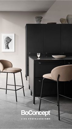 two bar stools are in front of a black cabinet and counter with an art print on the wall