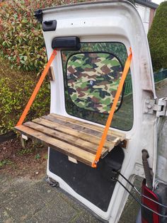 the back door of a van with a wooden shelf attached to it