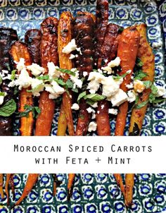 moroccan spiced carrots with feta and mint on a blue and green plate